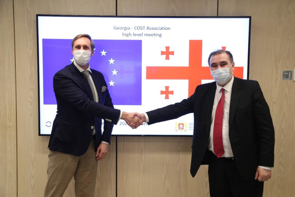 Georgia high-level COST meeting, ronald de bruin and dr mikheil chkhenkeli shake hands in front of flags