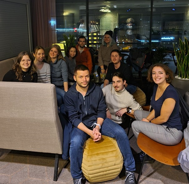 Photo of 10 people sitting on sofa's smiling at the camera