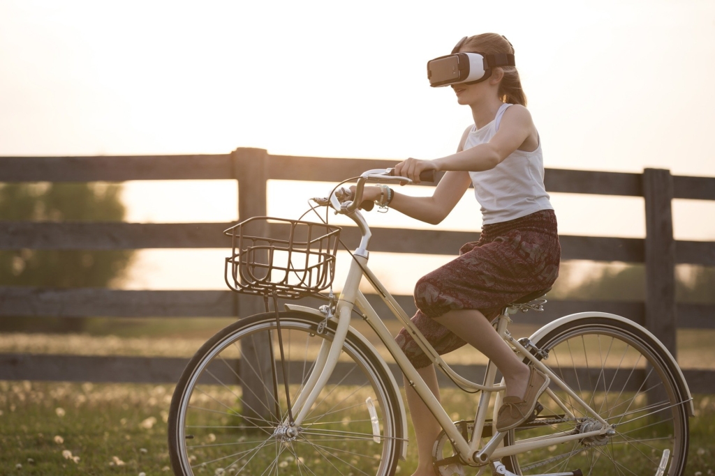 Photo of a girl riding a bike wearing a virtual reality headset
