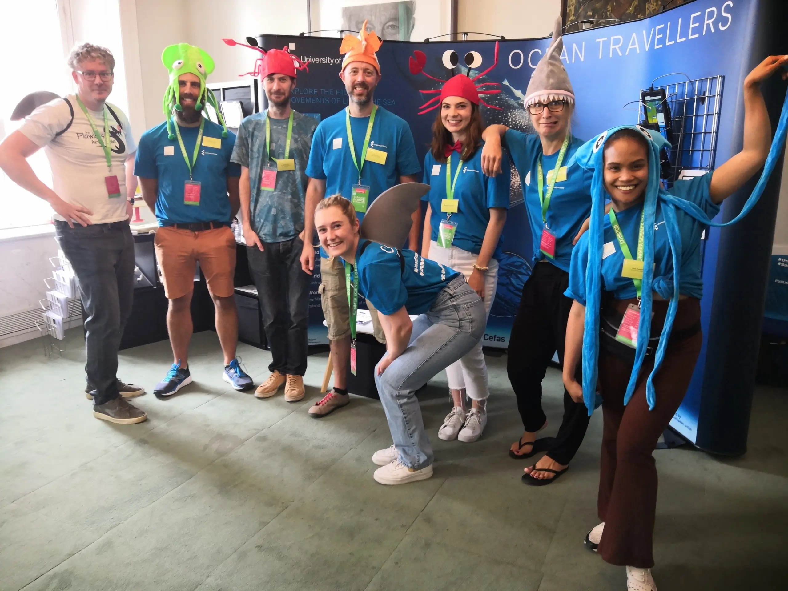 Photo of a team of animators wearing fun marine-themed hats such as crabs, sharks, octopus, and jelly fish.