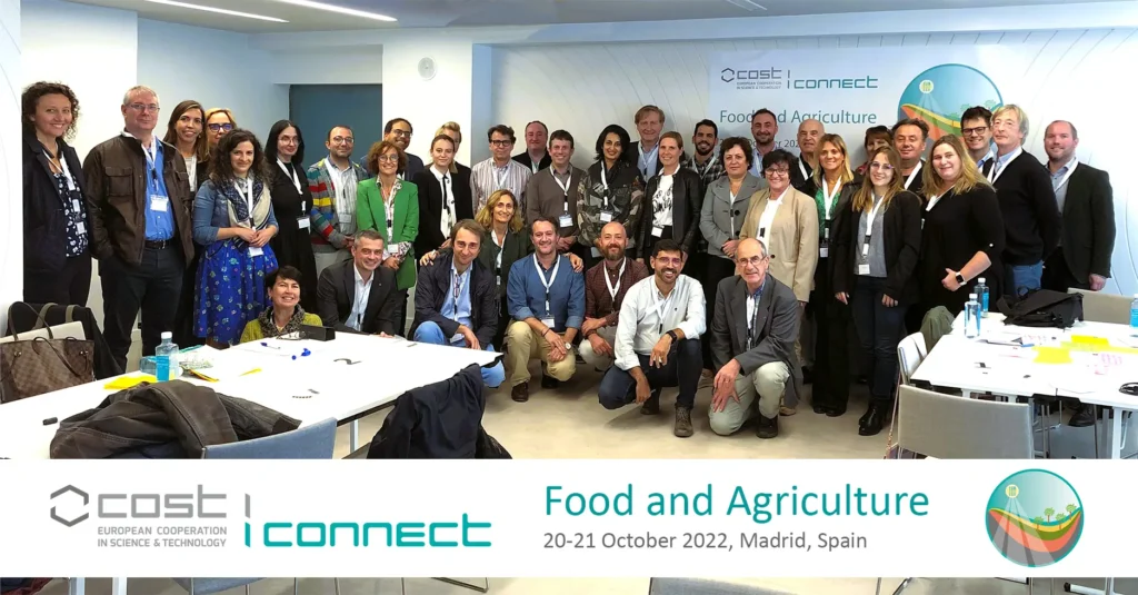 Group photo of 60+ people posing for a group photo in a meeting room