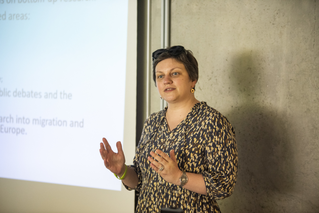Woman researcher standing in front of a project screen giving a talk