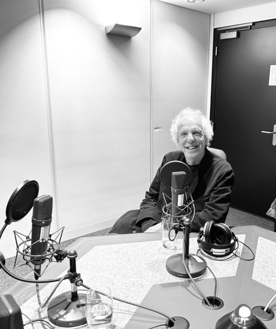 Man sitting in a radio studio in front of a microphone ready to be interviewed