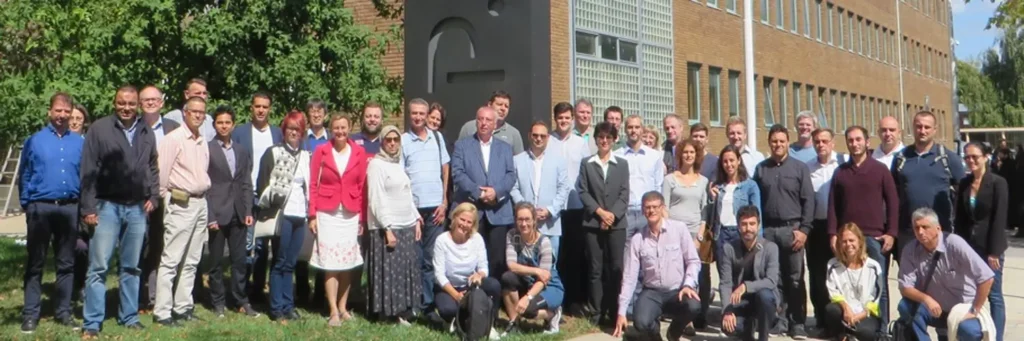 group photo of about 30 people in front of a building