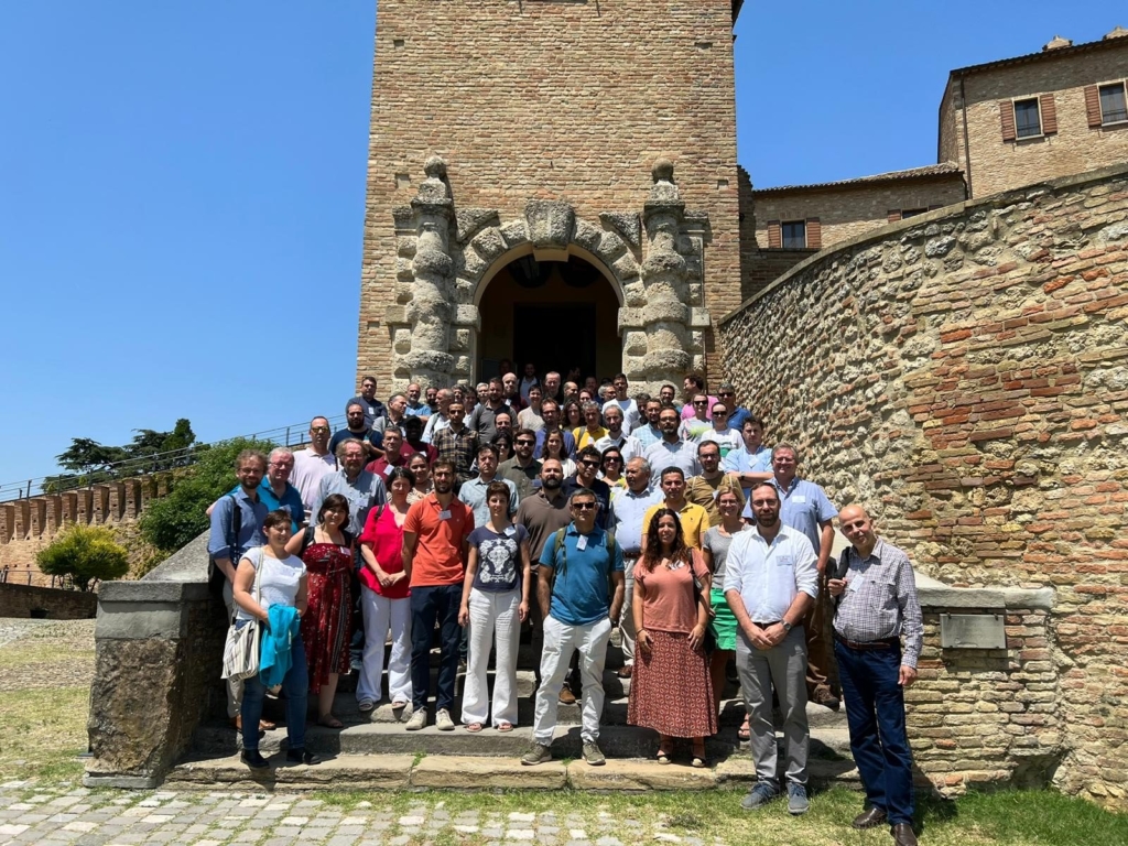 Group of researchers standing together on steps infront of a castle turret