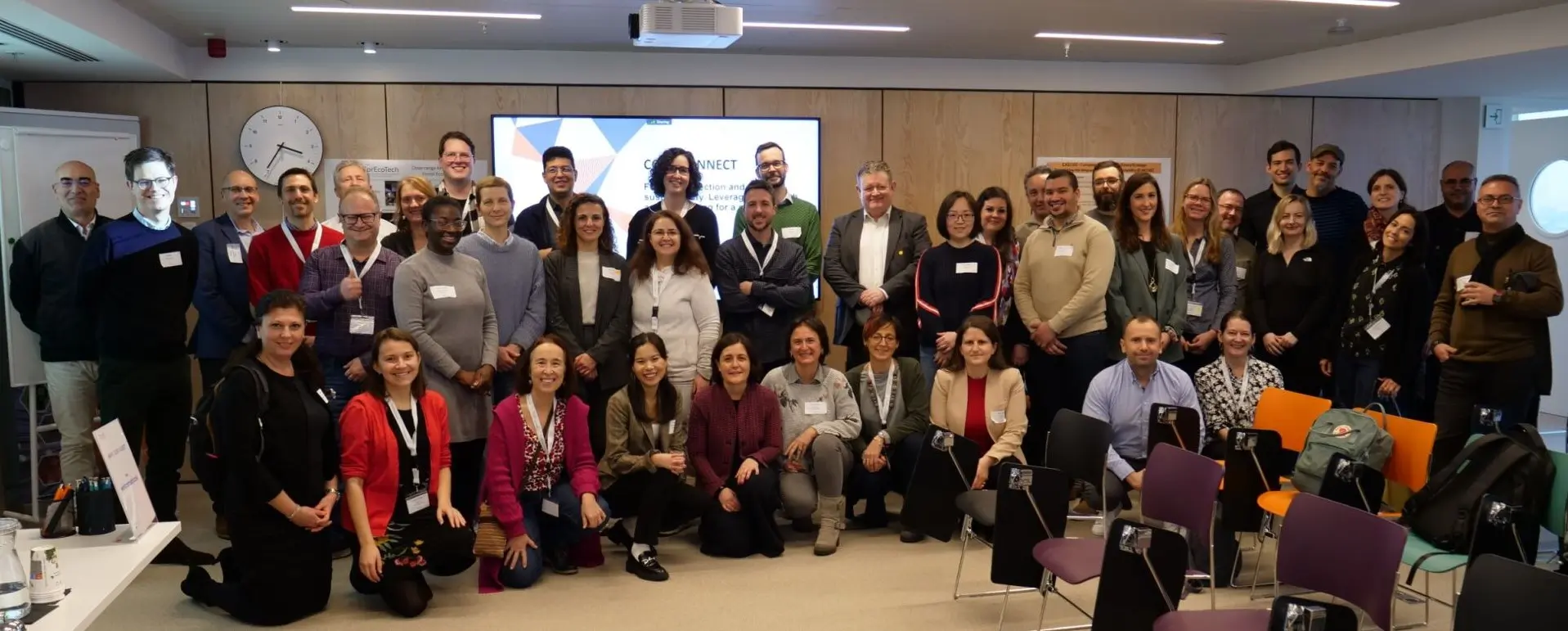 group photo of the event participants in front of the screen