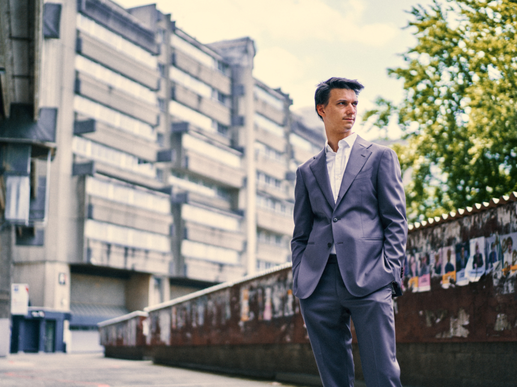 Photo of a young man in a suit with an urban background